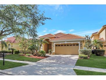 Charming single-story home with a tile roof, brick driveway, and meticulously manicured landscaping at 11556 Via Lucerna Cir, Windermere, FL 34786