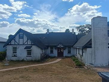 Charming Tudor-style home featuring a unique exterior, peaked roof and spacious front yard at 2603 E Lake Hartridge Dr, Winter Haven, FL 33881