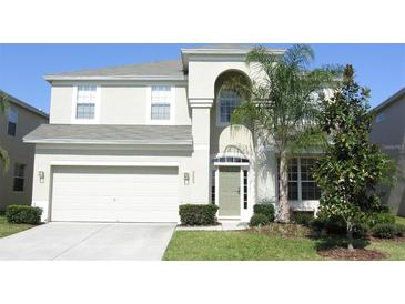 Charming two-story home with lush green lawn, attached two-car garage, and covered entryway at 2605 Daulby St, Kissimmee, FL 34747