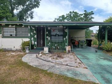 Modest single story home with covered parking and green trim on an overcast day at 442 Fanfair Ave, Orlando, FL 32811