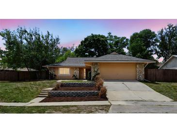 Charming single-story home featuring stone accents, a two-car garage and meticulous landscaping at 448 Sundown Trl, Casselberry, FL 32707