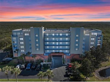 Stunning exterior view of the condo building against a vibrant sunset sky at 5300 S Atlantic Ave # 16-505, New Smyrna Beach, FL 32169