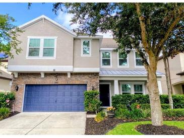 Charming two-story home with a blue garage door and beautifully landscaped front yard at 540 Seven Oaks Blvd, Winter Springs, FL 32708