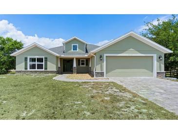 Charming one-story home with a well-manicured lawn, two-car garage, and inviting entryway at 7017 Bridle Path, St Cloud, FL 34771