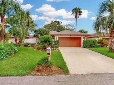 Charming single-story home features lush landscaping, a well-manicured lawn and an attached two-car garage at 9 Abbey Ct, Haines City, FL 33844