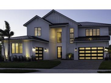 Stunning two-story home with black-trimmed windows, modern lighting, and three-car garage at 9155 Sheen Sound St, Orlando, FL 32836