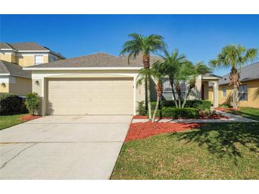 Charming home featuring a two-car garage, manicured lawn, and tasteful landscaping at 1175 Seasons Blvd, Kissimmee, FL 34746