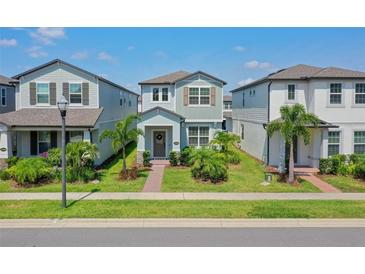 Charming two-story home with a well-manicured lawn and tropical landscaping at 13748 Werrington Dr, Winter Garden, FL 34787