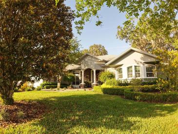 Charming single-story home with a lush green lawn and mature trees in a desirable neighborhood at 1802 Hartford Path, The Villages, FL 32162