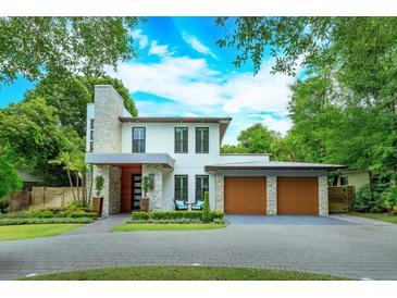 Stunning two-story modern home with stone accents and a spacious three-car garage at 1831 Mizell Ave, Winter Park, FL 32789