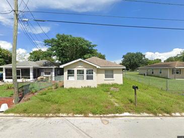 Charming single-story home featuring a well-maintained yard and a classic design, complemented by mature trees and a serene neighborhood setting at 230 D St, Lake Wales, FL 33853