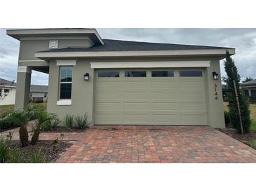 A beautiful home featuring a spacious garage and a meticulously designed brick driveway at 3144 Songbird Cir, Harmony, FL 34773