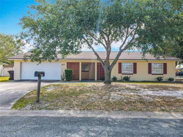 Charming one-story home with a mature tree, attached garage, and well-maintained front yard at 601 Francis St, Kissimmee, FL 34741