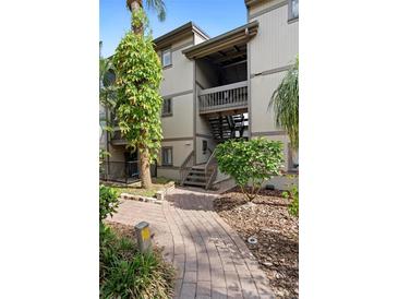 Charming condo building featuring a brick walkway surrounded by lush landscaping at 652 Lake Villas Dr # D, Altamonte Springs, FL 32701