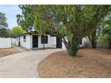 Charming single-story home showcasing the front yard with mature trees and a concrete driveway at 114 Spring Lake Cir, Ocoee, FL 34761