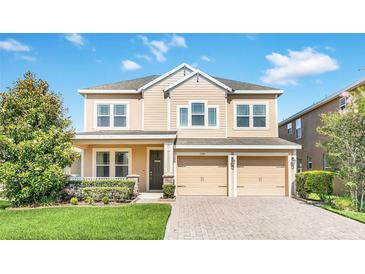 Two-story home featuring a two-car garage, manicured lawn, and a light beige color scheme at 1545 Caterpillar St, St Cloud, FL 34771