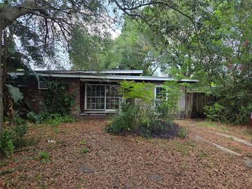 Modest single story home with brick facade partially obscured by overgrown landscaping in the front yard at 2638 S Laurel Ave, Sanford, FL 32773