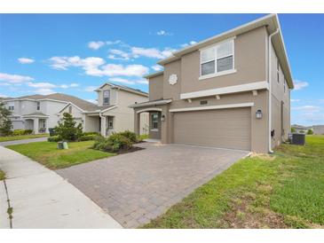 Charming two-story home featuring a two-car garage, neutral stucco exterior, and a neatly paved driveway at 2932 Muller Oak Loop, Ocoee, FL 34761