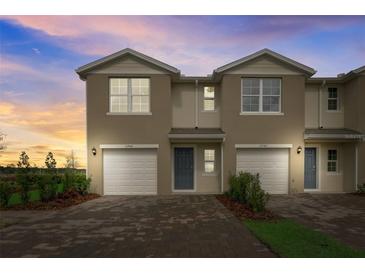 Charming townhome exterior with attached garages and manicured landscaping at 2971 Brie Hammock Bnd, St Cloud, FL 34773