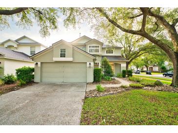 Two-story home featuring a well-manicured lawn, rock garden, and a convenient two-car garage at 4448 Riverton Dr, Orlando, FL 32817