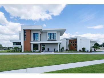 Modern home showcasing clean lines, sleek design, and a well-manicured lawn on a sunny day at 5023 Sawyer Cove Way, Windermere, FL 34786