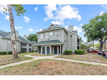 Inviting two-story condo showcasing a walkway, manicured landscaping, and convenient parking at 6100 Westgate Dr # 101, Orlando, FL 32835