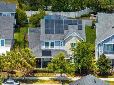 Charming two-story home featuring solar panels, a cozy front porch, and lush landscaping, in an attractive neighborhood at 7873 Dausset St, Orlando, FL 32827