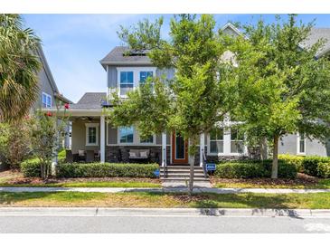 Charming two-story home with a cozy front porch, manicured landscaping, and beautiful curb appeal at 7873 Dausset St, Orlando, FL 32827