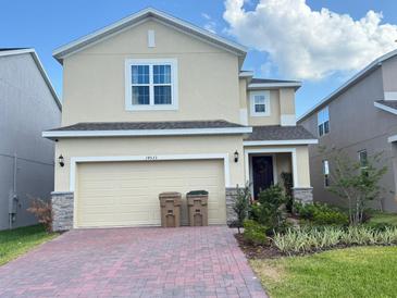 Charming two-story home with brick driveway, two-car garage, and well-maintained landscaping at 14533 Crestavista Ave, Clermont, FL 34714