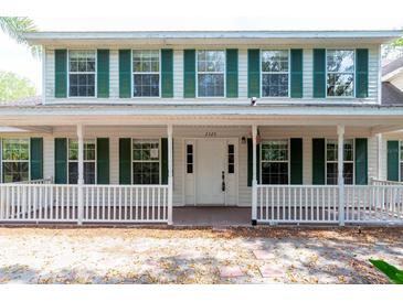 Charming two-story home featuring a welcoming front porch and classic white siding with green shutters at 2320 Red Ember Rd, Oviedo, FL 32765