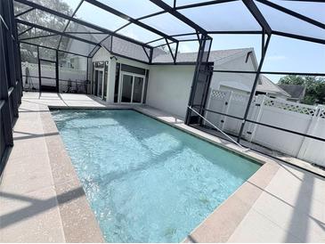 Screened in pool with deck and partial house view at 402 Ravenshill Way, Deland, FL 32724