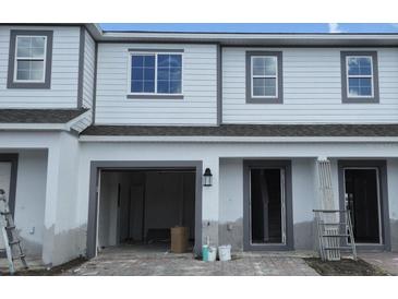 Exterior view of townhome featuring a one-car garage and covered entry at 5113 Prairie Preserve Run, St Cloud, FL 34772