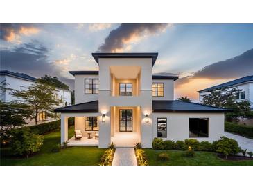 Striking modern two-story home with black-trimmed windows and manicured landscaping at sunset at 11303 Windermere Rd, Windermere, FL 34786