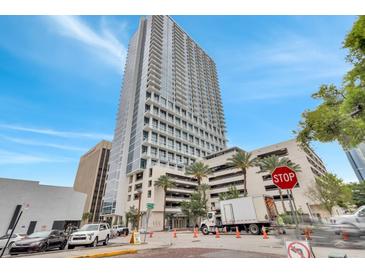 Modern high rise building with a glass facade and a parking garage in an urban setting at 150 E Robinson St # 2002, Orlando, FL 32801