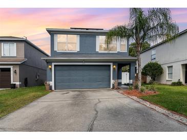 Charming two-story home featuring a two-car garage, well-manicured lawn and a lovely palm tree in the front yard at 2117 Stone Abbey Blvd, Orlando, FL 32828