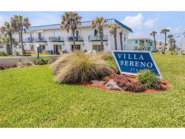 Beautiful condo building with ocean views and lush landscaping; signage reads Villa Sereno at 2750 Ocean Shore Blvd # 350, Ormond Beach, FL 32176