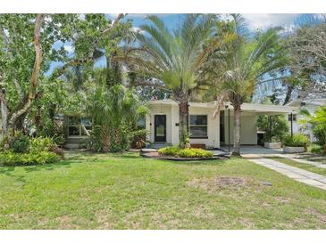 Charming single-story home with lush landscaping, mature trees, and a convenient carport at 318 E Jersey St, Orlando, FL 32806