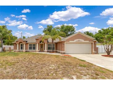 Charming single-story home with a two-car garage, lush landscaping, and a well-manicured lawn at 514 Richmond Ave, Deltona, FL 32725