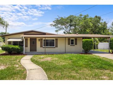 Charming single story home with well-maintained lawn, a walkway, and a covered front porch and carport at 891 N Wayman St, Longwood, FL 32750