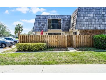 Exterior of townhome featuring a wood fence, balcony and well-maintained landscaping at 917 Royal Oak Blvd, Leesburg, FL 34748