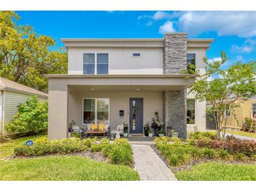 Charming two-story home with a stone accent chimney, inviting front porch, and well-manicured landscaping at 1127 W Harvard St, Orlando, FL 32804