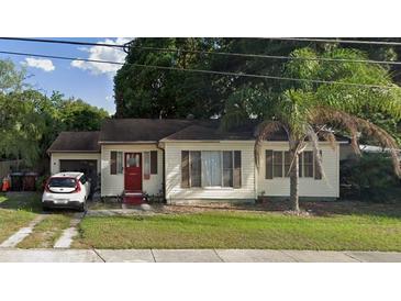 Charming single-story home featuring a red front door and a driveway with a parked car at 2312 Corrine Dr, Orlando, FL 32803