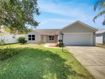 Charming single-story home with well-maintained lawn and landscaping, plus attached two-car garage at 2708 La Posada Dr, The Villages, FL 32162