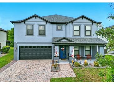 Charming two-story home with a brick-paved driveway, attached garage, and cozy front porch at 2926 Boating Blvd, Kissimmee, FL 34746
