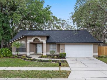 Charming one-story home featuring a two-car garage and a beautifully landscaped front yard with mature trees at 4161 Leafy Glade Pl, Casselberry, FL 32707