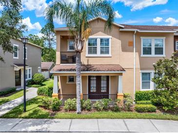 Inviting two-story townhome with a charming front porch and lush landscaping at 5464 Factors Walk Dr, Sanford, FL 32771