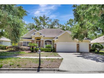 Charming home featuring a three-car garage, arched entryway and mature landscaping at 626 Green Rock Ct, Apopka, FL 32712