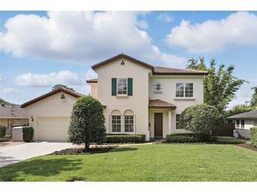 Charming two-story home boasts a manicured lawn, tile roof, and verdant landscaping at 123 Tangelo Court, Maitland, FL 32751
