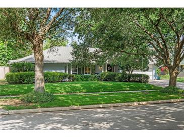 Charming single-story home with mature trees, lush lawn, and manicured shrubbery at 627 Darcey Dr, Winter Park, FL 32792