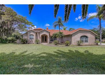 Charming brick home with lush lawn, mature trees, and inviting curb appeal at 12202 Rambling Oak Blvd, Orlando, FL 32832